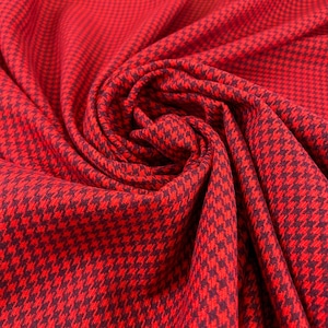 Könnte beinhalten: Nahaufnahme eines leuchtend roten Stoffes mit einem klassischen Hahnentrittmuster in einem dunkleren Rotton. Der Stoff ist drapiert und gefaltet, wodurch die Textur und das Design zur Geltung kommen. Dieser Stoff eignet sich für verschiedene Nähprojekte.