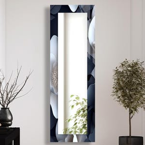 Peut inclure: Un grand miroir rectangulaire avec un cadre à motif floral dans les tons bleu marine, blanc et gris. Le miroir est dans une pièce lumineuse avec une table d'appoint noire, un vase et une plante en pot. Le miroir mesure environ 170 cm de haut.