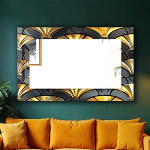 May include: A rectangular mirror with a black and gold Art Deco frame hangs above a mustard yellow sofa. The mirror is a prominent feature in a room with a dark green wall. A wooden coffee table is in front of the sofa.