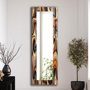 Peut inclure: Un grand miroir rectangulaire avec un cadre décoratif présentant un motif tourbillonnant dans des tons de marron, de bleu et d'orange. Le miroir est positionné verticalement contre un mur blanc, reflétant la pièce. Le thème général est la décoration intérieure.