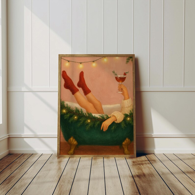 May include: A framed print depicts a person relaxing in a green clawfoot bathtub, wearing red socks and holding a cocktail. The tub is decorated with greenery and lights, creating a festive atmosphere. The artwork has a warm, inviting color palette.