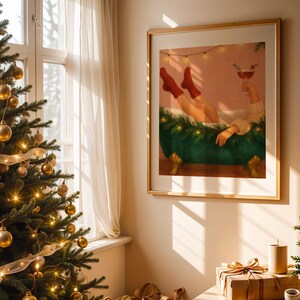 May include: A framed art print depicts a person relaxing in a green bathtub, holding a cocktail. The person is wearing red socks. The artwork is in a room with a Christmas tree and wrapped gifts.