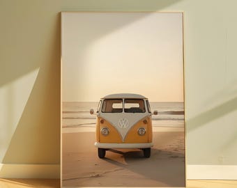 Puede incluir: Impresión enmarcada de una furgoneta Volkswagen amarilla y blanca en una playa al atardecer. El vehículo está orientado hacia el espectador, con el mar y el cielo al fondo. La imagen evoca una sensación de viaje y nostalgia.