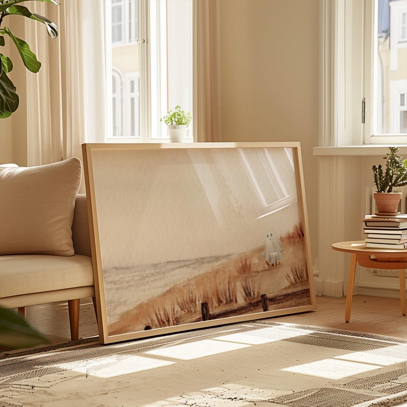 May include: A framed print of a watercolor painting depicting a beach scene with two figures in the distance. The painting is in shades of brown, beige, and white, with a soft, dreamy feel.