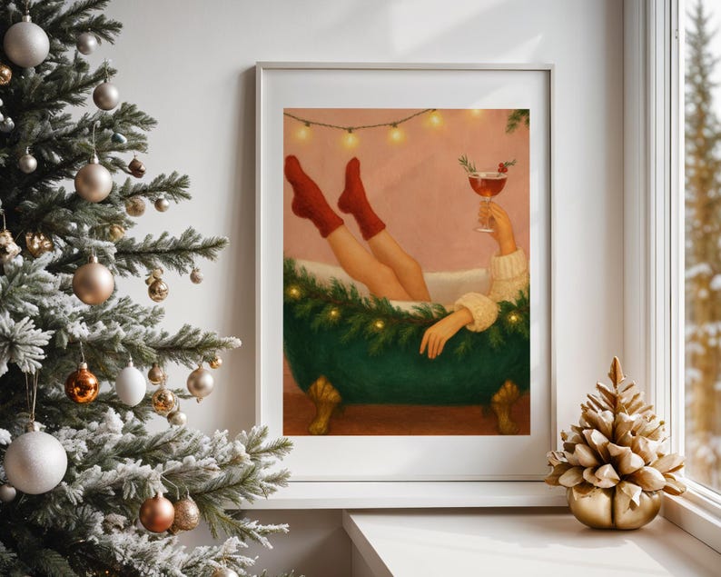 May include: A framed art print depicts a person relaxing in a green bathtub, wearing red socks and holding a cocktail. The tub is decorated with greenery and lights. A Christmas tree and gold decorative tree are in the foreground.