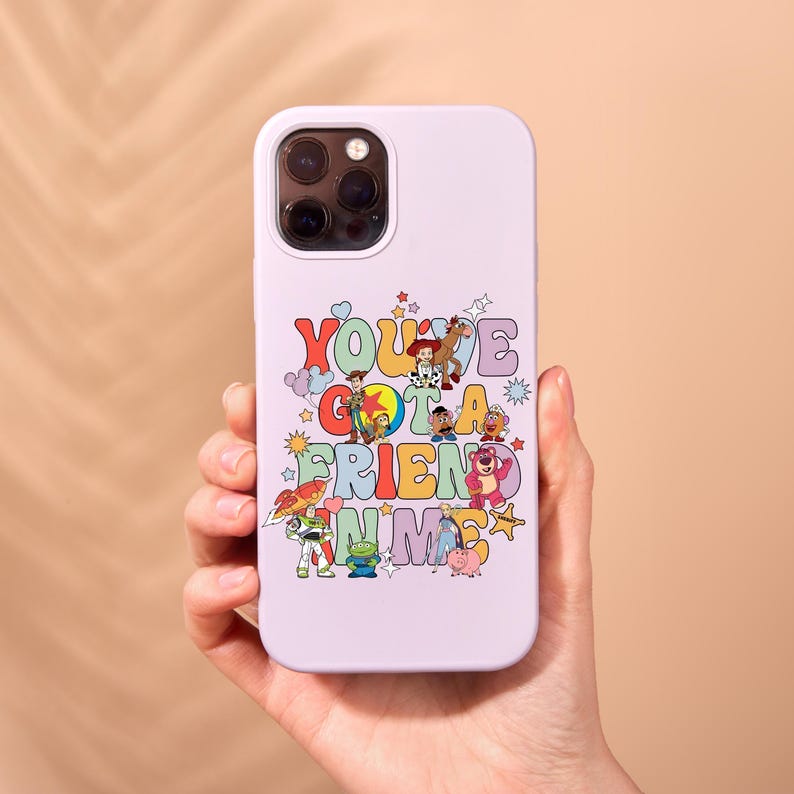 K&ouml;nnte beinhalten: Eine helllila Handyh&uuml;lle mit einer bunten Grafik von Figuren aus dem Toy Story-Franchise. Die Grafik enth&auml;lt den Text "You've Got a Friend in Me".