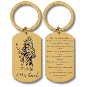 May include: Gold-tone keychain with a Saint Christopher pendant featuring a black and white image of Saint Christopher carrying a child. The pendant has the text "Dear Saint Christopher, Protect me today in all my travels Along the road's way. Give your warning sign if danger is near So that I may stop while the path is clear. Be at my window and direct me through When the vision blurs from out of the blue. Carry me safely to my destined place, Like you carried Christ in your strong embrace. Amen." and the name "Michael" engraved on the back.