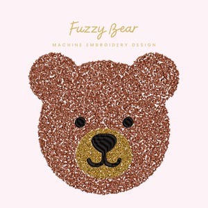 Op de afbeelding: Een bruin teddybeergezicht met zwarte ogen en neus, en een goudkleurige snuit. De beer is gemaakt van een fuzzy materiaal. De tekst "Fuzzy Bear" en "MACHINE EMBROIDERY DESIGN" staan in gouden script boven de beer.