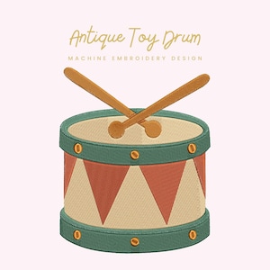 Puede incluir: Un diseño bordado de un tambor de juguete antiguo. El tambor presenta un parche beige, un borde verde y un cuerpo con estampado rojo y beige. El diseño incluye dos baquetas de madera y el texto "Antique Toy Drum".