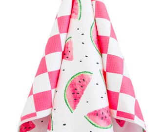 May include: A pink and white kitchen towel with a watermelon print. The towel is folded and hanging from a hook.