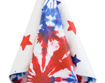 May include: A white towel with a red, white, and blue tie-dye pattern. The towel has stars printed on it and is hanging from a hook.