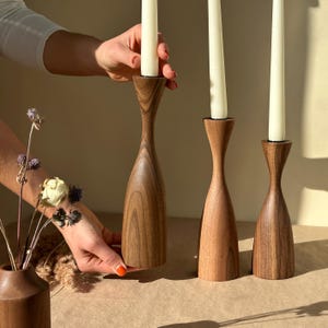 素朴なクルミ材のキャンドルホルダー、3 個セット。手作りの優雅さはモダンな室内装飾やギフトに最適です。