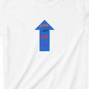 Puede incluir: Camiseta blanca con un diseño de flecha azul que apunta hacia arriba. La flecha contiene las palabras "cool kid life" en texto rojo y azul. La camiseta está hecha de un material suave y ligero.