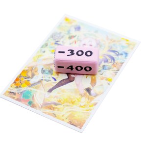 Showing a single negative 300 value Attack Marker on top of a card sleeve to compare sizes