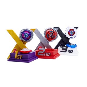 May include: Three tiered display stands labeled 1st, 2nd, and 3rd, each featuring a large X-shaped back support and a spinning top toy. The 1st place stand is purple, the 2nd is red, and the 3rd is white, with corresponding metallic tops.