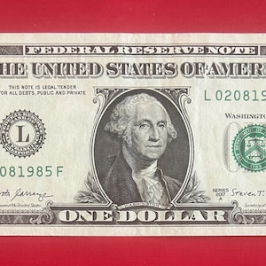 May include: A one dollar bill featuring a portrait of George Washington. The bill is in good condition and has the serial number L02081985F. The bill is a Federal Reserve Note and is legal tender for all debts, public and private.