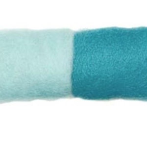 May include: A rectangular piece of felt, divided into two sections. One side is a light blue, the other is a darker teal blue. The felt has a soft, textured appearance, and is set against a white background.