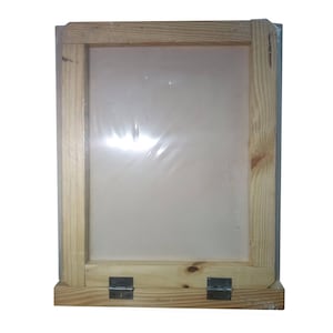May include: A wooden screen printing frame with a clear, stretched screen. The frame is made of light-colored wood and has metal hinges at the base. The screen is covered in a clear plastic wrap.