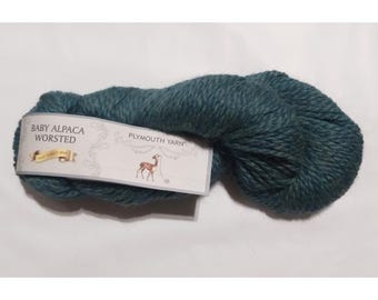 May include: A skein of teal blue Baby Alpaca Worsted yarn from Plymouth Yarn. The label features a small illustration of a deer.