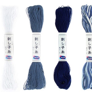 May include: Four spools of embroidery floss in different shades of blue and white. The spools are labeled "刺し子糸" which translates to "Sashiko thread" in English.