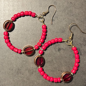 Bright red beaded earrings with glass bead accents.