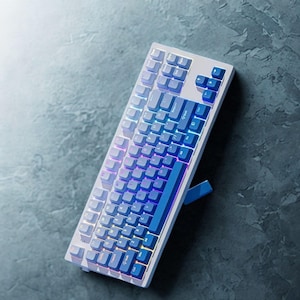 OEM profile gradient blue PBT keycaps arranged neatly on keycap tray.