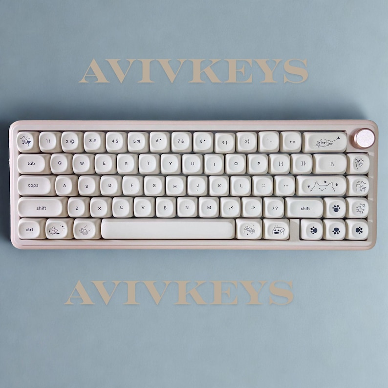 May include: A light pink mechanical keyboard with white keycaps. The keyboard has a compact layout with a round volume knob and cat-themed illustrations on some keys. The text "AVIVKEYS" is above and below the keyboard on a light blue background.