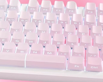 Könnte beinhalten: Nahaufnahme einer weißen und rosa mechanischen Tastatur. Die Tastatur hat hellrosa Tastenkappen mit weißer Beschriftung. Die Tasten sind in einem Standard-QWERTZ-Layout angeordnet. Der Markenname "AVMKEYS" ist unten sichtbar.