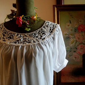 1970 vintage  crisp  white  rayon  peasant style blouse with  boat neck line, french lace,  short  raglan  puffy sleeves. Size Medium.