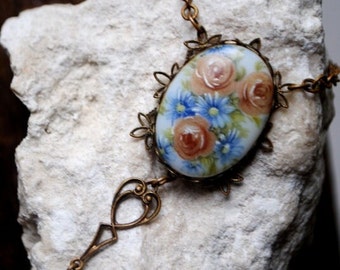 1910  Victorian original , gold tone metal  necklace with small pastel blue  cameo  pendant , hand painted dusty roses and blue  daisy's .