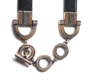 Stylish  vintage 1996 , black genuine leather belt with ornate , silver tone metal horseshoe buckle, adjustable ring. By Brighton. Size L.