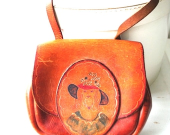 Boho vintage 1970 caramel-brown hand tooled  saddle,  cross body, rounded  bag with a large flap ad portrait of the lady with a flowers hat.