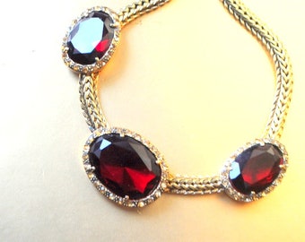 Statement vintage 1980, gold tone metal, collar -choker necklace with a  three  oval shape, faux , faceted garnet cabochons.  By Monet.