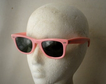 1984  vintage , bubblegum pink heavy plastic  sunglasses with dark green lenses. Made  by Wayfarer, Ray-Ban in USA, Model 5022.