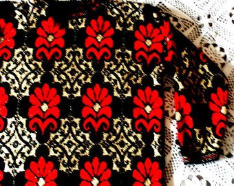 Festive vintage 1980s,  black acrylic, slouchy , christmas   sweater- tunic with a gold metallic cross  and red  flowers print. Size M-L.