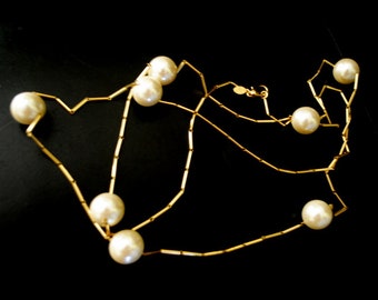 Modernist vintage 1980, gold tone metal, long  ( 58,0" ) , convertible  necklace with  large,  shiny  off white pearl  beads.  By Carolee.