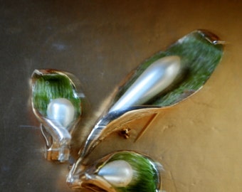 Retro vintage 60s gold tone metal  cala lily parure with a tear drop shape faux pearl as a centerpiece and green background.