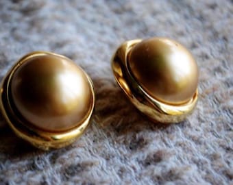 Pendientes de clip estilo mod Carollee de 1980 con bola de metal en tono dorado satinado rodeada de un marco asimétrico llamativo.