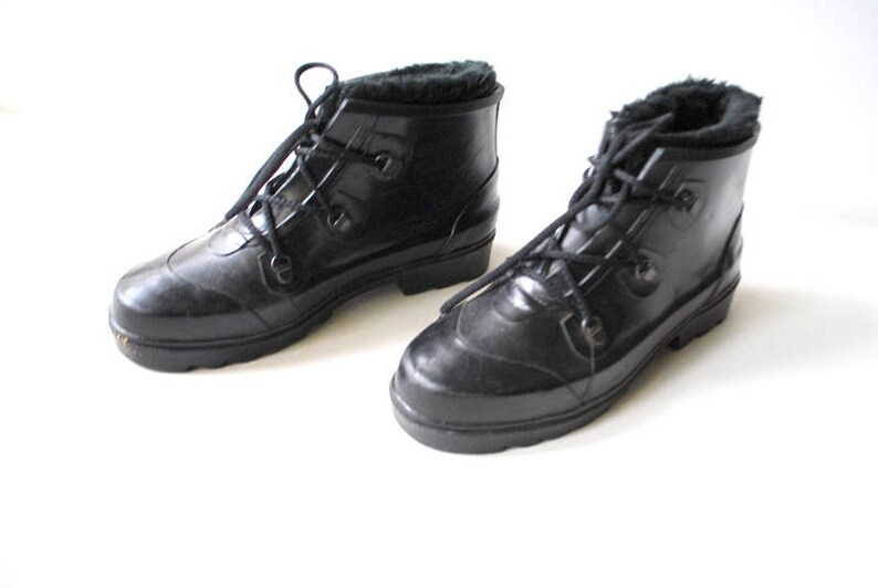 May include: A pair of black rubber boots with faux fur lining. The boots have a lace-up design and a rounded toe. The boots are likely waterproof and suitable for cold weather.