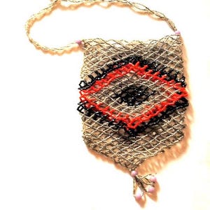 May include: A vintage beaded purse with a woven net design. The purse features a central diamond pattern in red and black, with a beaded handle and a decorative tassel at the bottom. The purse is made of small, shimmering beads.