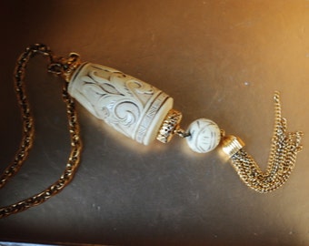 Asian tribal vintage 70s gold tone metal necklace with  oversize, ivory lucite pendant. Made by  Trifari Crown.