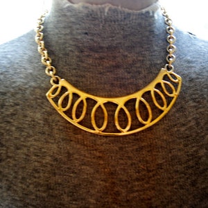 Statement vintage jaren &#39;80 goudkleurige metalen slabbetje ketting met een swashes design. gemaakt door Monet.