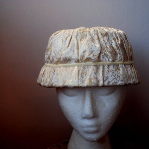 Mod vintage 1960s,  antique white -gold baroque , cloche style, cinched , sturdy hat. Size  22. Mint condition.