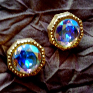 Glamour  vintage 1980s, gold tone metal,   wide  clip on earrings with a  faceted star and moon  rhinestone as a centerpiece.  Marla  Buck.