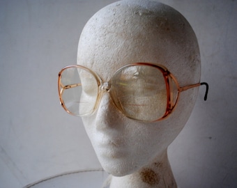 1970 vintage  iconic  style , oversize  eye glasses  , pastel peach lucite frame, pastel pink  bifocal lenses, v shape  arm's base.