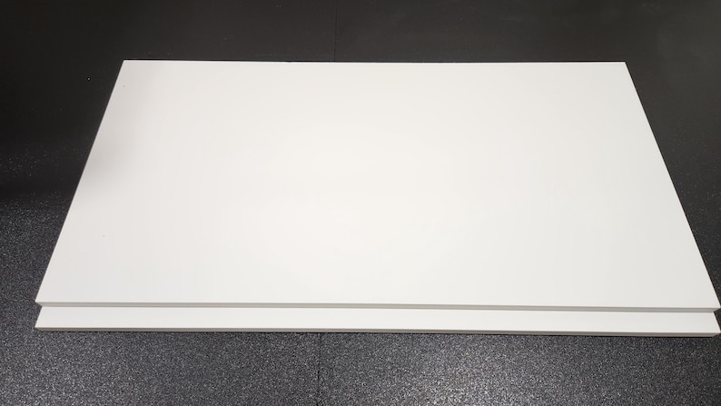 May include: Two white foam core boards stacked on top of each other. The boards are rectangular and have a smooth surface.