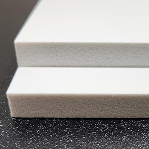 May include: Two white foam boards stacked on top of each other. The boards are smooth and have a slightly textured surface.