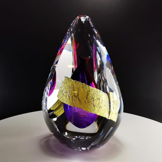 A one-off hand-blown glass sculpture in deep violet and gold — the kind of piece that looks like it escaped a gallery and ended up on your shelf.