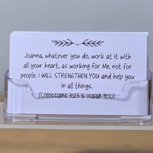 May include: A clear acrylic card holder filled with white cards. The cards have black text that reads "Joanna, whatever you do, work at it with all your heart..." and references Colossians 3:23 & Isaiah 41:10.