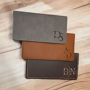May include: Three personalized checkbook covers in gray, brown, and dark brown. Each cover features initials and names, with contrasting stitching. The gray cover displays "David Smith", the brown cover shows "A/D", and the dark brown cover reads "Daniel Norman".